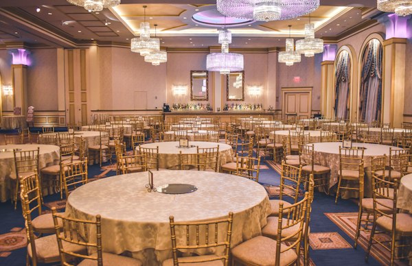 Gran salón de gala climatizado con arañas de cristal y mesas circulares